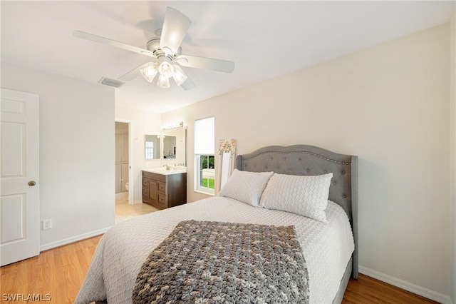 bedroom with ceiling fan, light hardwood / wood-style floors, and ensuite bathroom