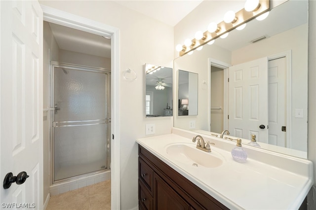 bathroom featuring a shower with shower door, vanity, ceiling fan, and tile floors