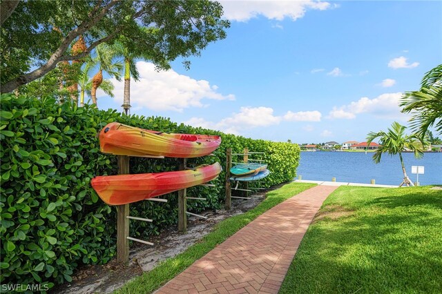 view of property's community with a lawn and a water view