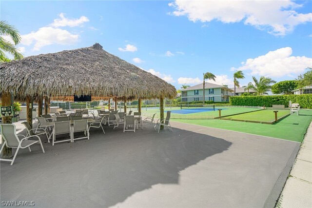 view of home's community featuring tennis court