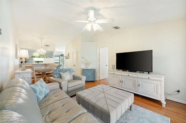 living room featuring light hardwood / wood-style flooring and ceiling fan with notable chandelier