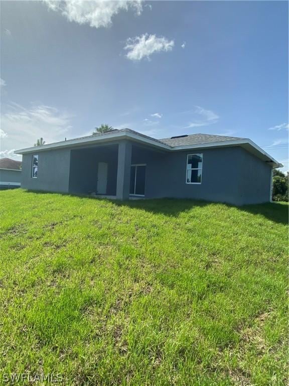 back of house featuring a lawn