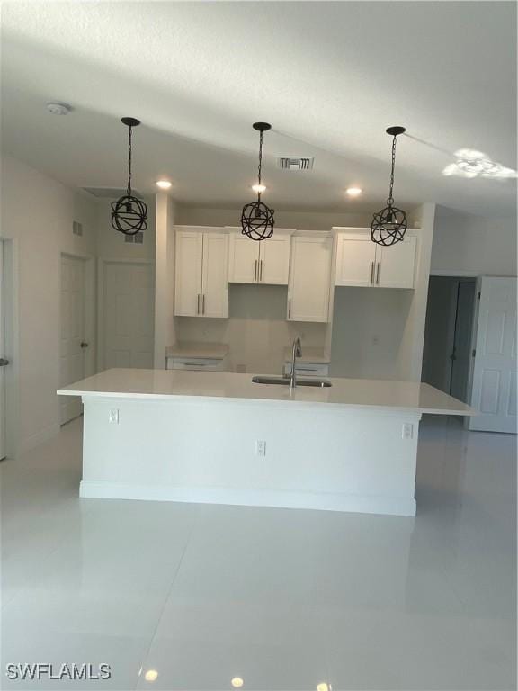 kitchen with a large island, sink, white cabinetry, and decorative light fixtures