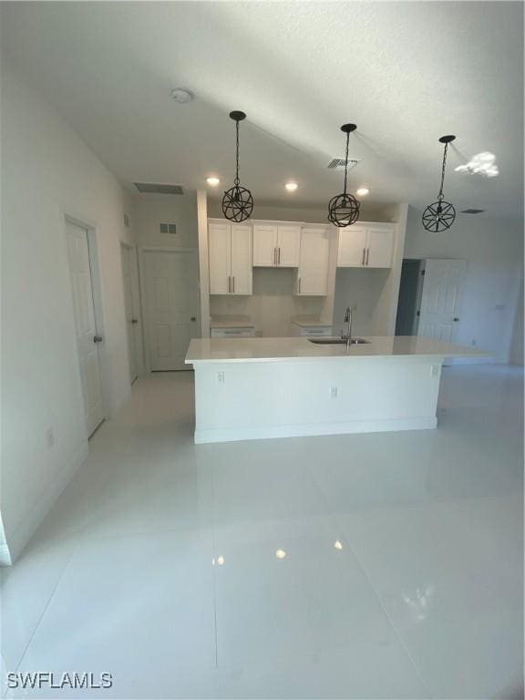 kitchen featuring a spacious island, sink, hanging light fixtures, and white cabinets