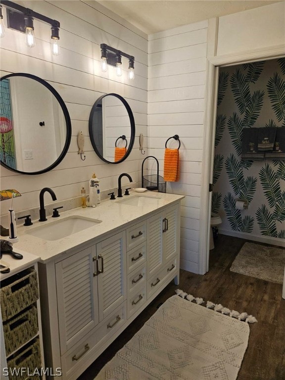 bathroom featuring wood walls, toilet, vanity, and hardwood / wood-style flooring