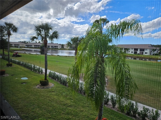 surrounding community featuring a lawn and a water view