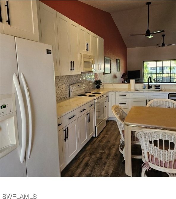 kitchen featuring white cabinets, decorative backsplash, white appliances, and vaulted ceiling