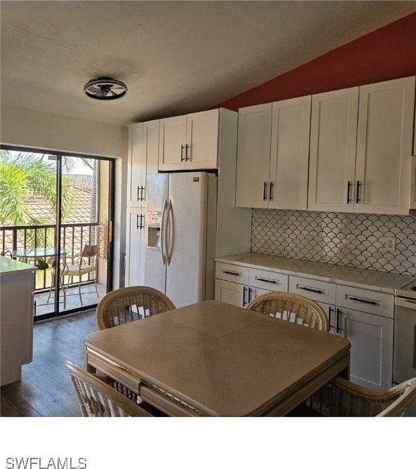 kitchen with backsplash, white cabinetry, white fridge with ice dispenser, and dark wood-type flooring