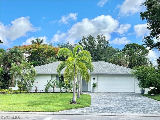 ranch-style home with a front lawn and a garage