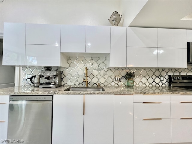 kitchen with light stone countertops, sink, backsplash, and stainless steel dishwasher