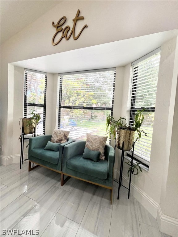 sitting room featuring vaulted ceiling and tile flooring