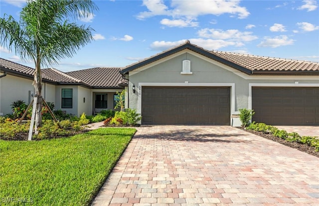 view of front of home with a tile roof, decorative driveway, an attached garage, and stucco siding