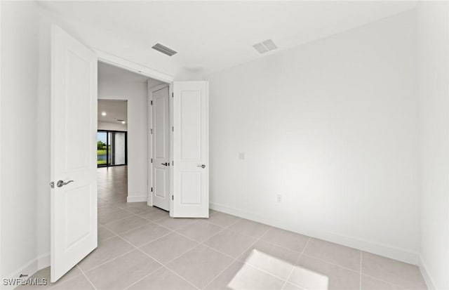 spare room with light tile patterned floors, baseboards, and visible vents