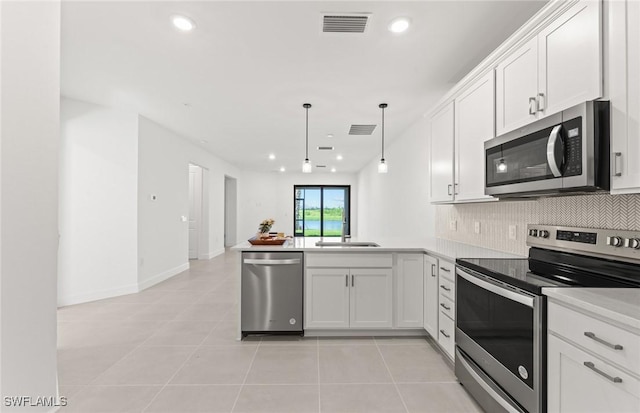 kitchen with visible vents, backsplash, white cabinetry, a peninsula, and stainless steel appliances