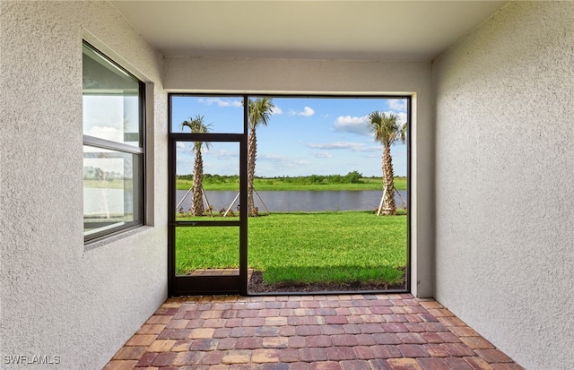 unfurnished sunroom featuring a water view and a healthy amount of sunlight