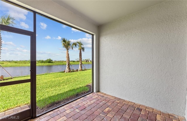 unfurnished sunroom with a water view