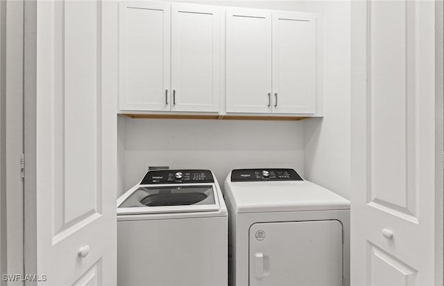 clothes washing area featuring independent washer and dryer and cabinets