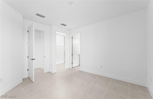 spare room featuring light tile patterned floors, baseboards, and visible vents