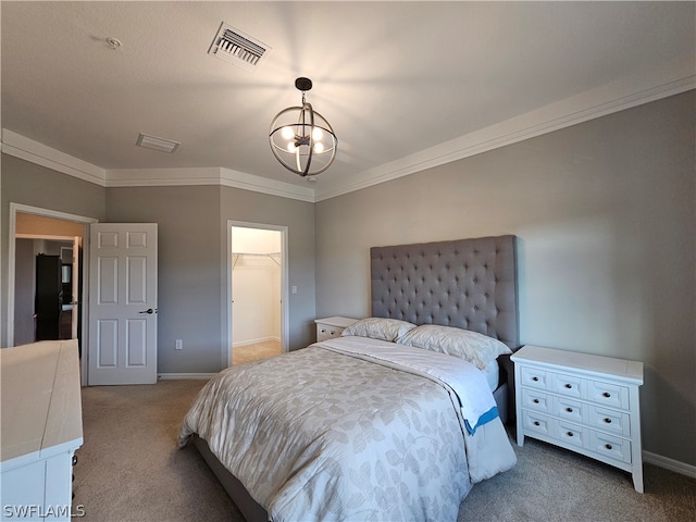 bedroom featuring carpet, a walk in closet, ornamental molding, and a closet