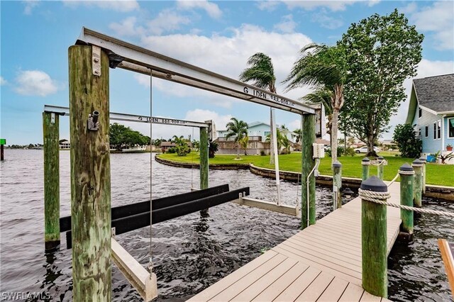 view of dock with a yard and a water view