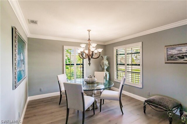 dining room featuring a chandelier, hardwood / wood-style flooring, and ornamental molding