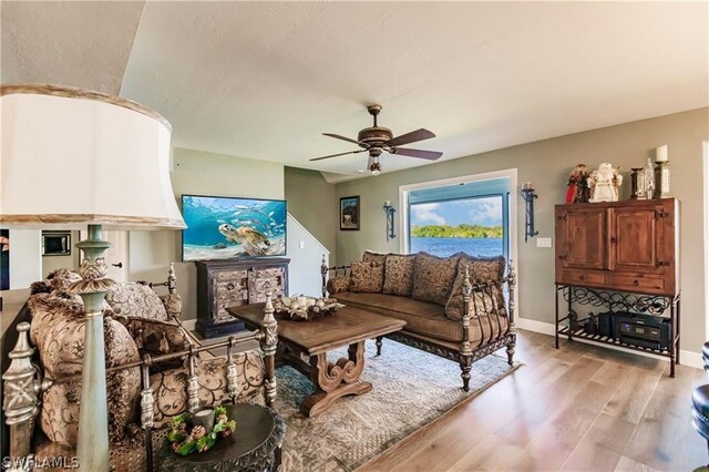 living room with ceiling fan and light wood-type flooring