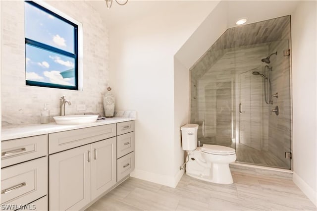 bathroom featuring vanity, a shower with shower door, tasteful backsplash, and toilet