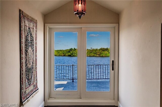 doorway with a water view and vaulted ceiling