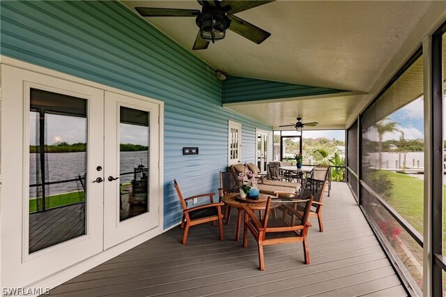 sunroom with ceiling fan, a water view, lofted ceiling, and french doors