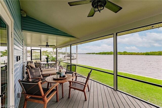 sunroom / solarium featuring ceiling fan, a healthy amount of sunlight, a water view, and lofted ceiling