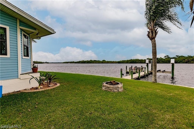 view of yard with a water view, a dock, and a fire pit