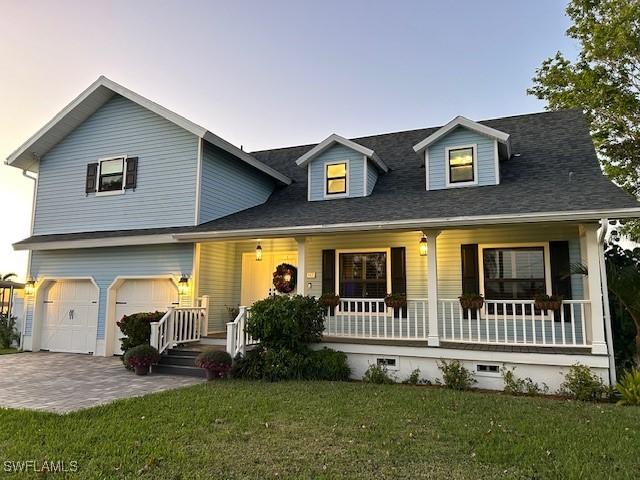 view of front of house with a porch, a garage, and a yard