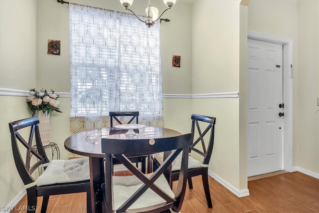 dining room with a notable chandelier and wood-type flooring