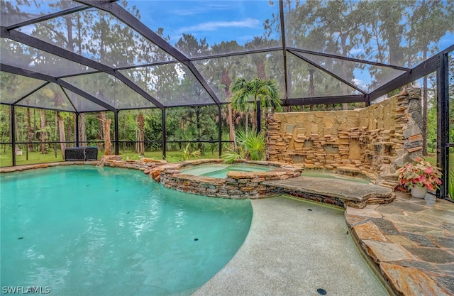 view of swimming pool featuring glass enclosure and an in ground hot tub