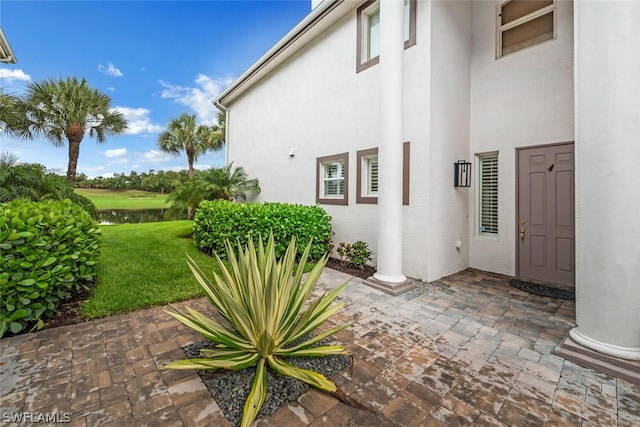 doorway to property with a lawn