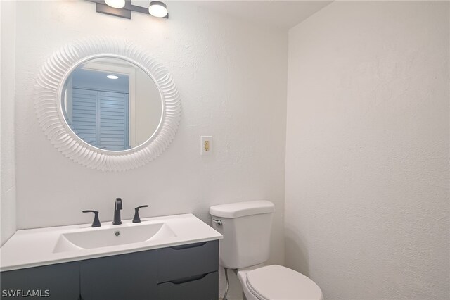 bathroom featuring toilet and vanity