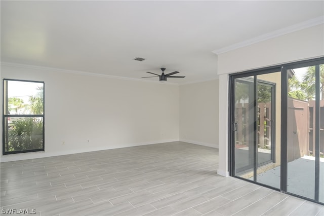 unfurnished room featuring ceiling fan, light wood-type flooring, a wealth of natural light, and crown molding