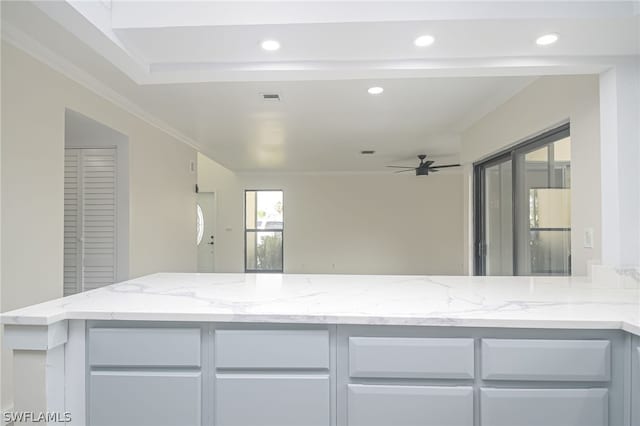 kitchen with ceiling fan, crown molding, white cabinets, and light stone countertops