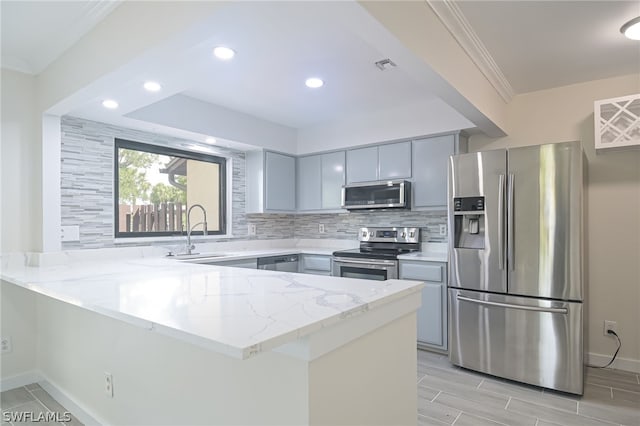 kitchen featuring stainless steel appliances, sink, kitchen peninsula, and gray cabinets