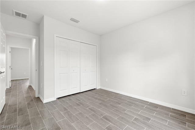 unfurnished bedroom with hardwood / wood-style floors and a closet