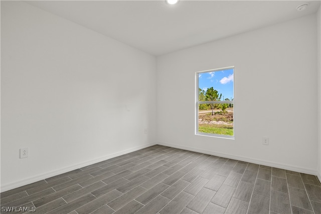 empty room with dark hardwood / wood-style flooring