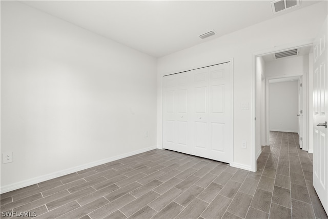 unfurnished bedroom featuring hardwood / wood-style flooring and a closet