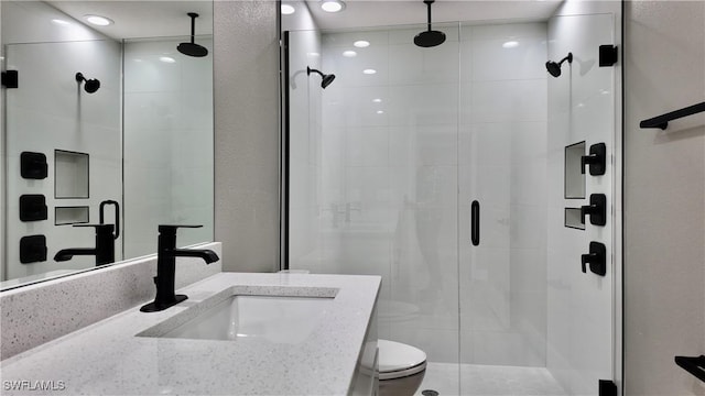 bathroom featuring toilet, an enclosed shower, and vanity