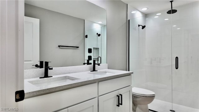 bathroom featuring vanity, toilet, and an enclosed shower