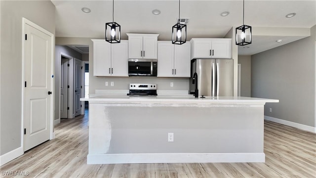 kitchen featuring white cabinetry, a center island with sink, pendant lighting, and appliances with stainless steel finishes