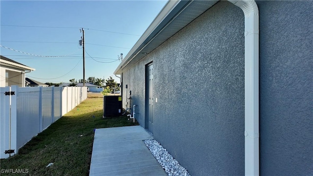 view of property exterior with a lawn and central air condition unit