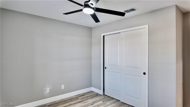 unfurnished bedroom featuring ceiling fan, a closet, and light hardwood / wood-style flooring