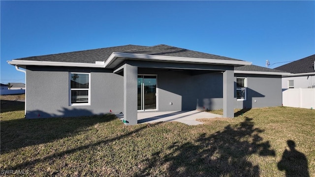 rear view of property with a lawn and a patio