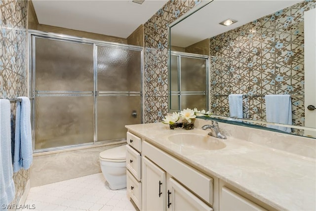 full bathroom with tile patterned flooring, vanity, bath / shower combo with glass door, and toilet