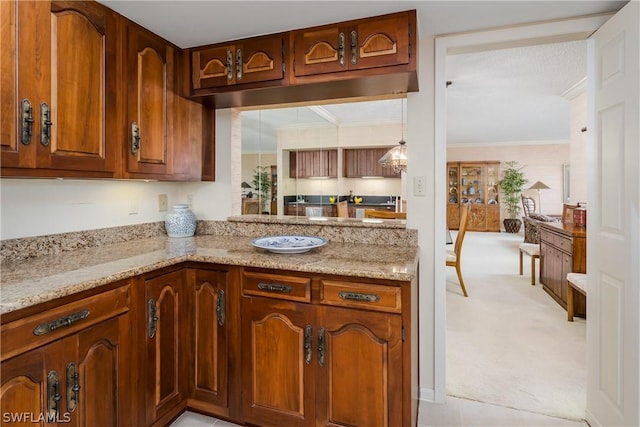 kitchen featuring light carpet, light stone counters, and ornamental molding